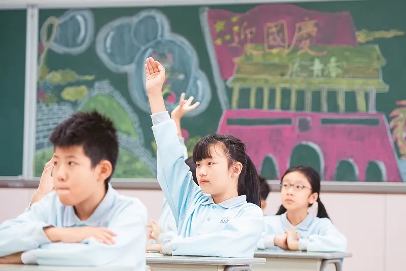 澳門中小學學生使用的教材《品德與公民》中有豐富的關于國情、國旗、國歌的內容,學生們可以從中學到很多關于祖國的知識,培養對祖國和澳門的感情。圖為2019年11月25日,澳門濠江中學附屬英才學校的學生在課堂上舉手回答老師提問。 新華社記者 張金加/攝